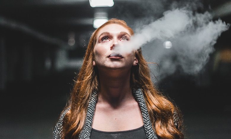 Woman in the act of vaping the electronic cigarette