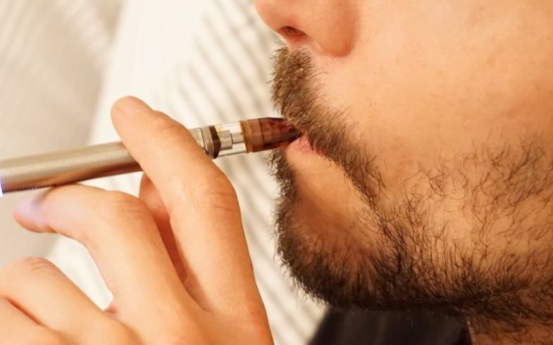 Boy vaping with a plastic drip tip