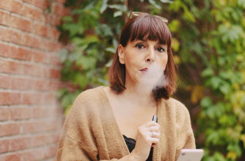 Woman using cheek e-cigarette