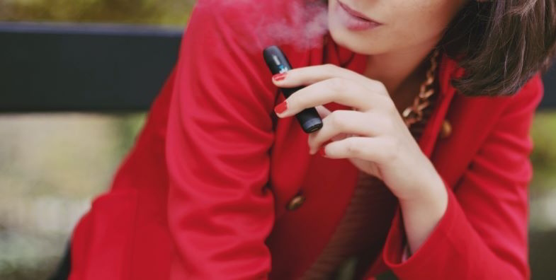 Woman vaping with a compact electronic cigarette