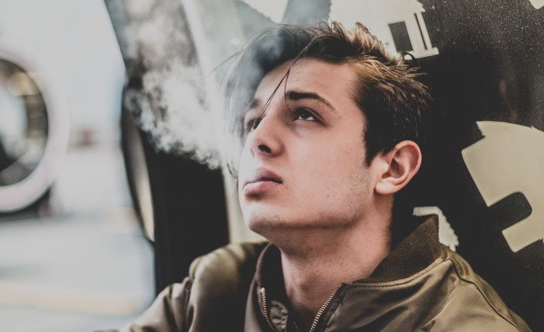 Boy vaping a disposable electronic cigarette