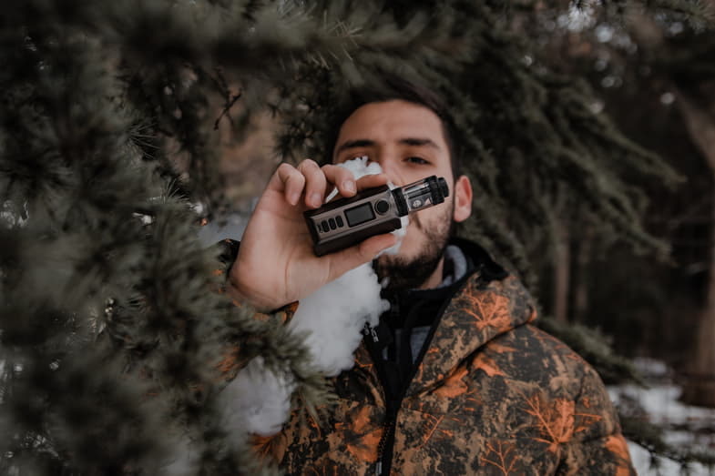 Boy vaping with a modern electronic cigarette