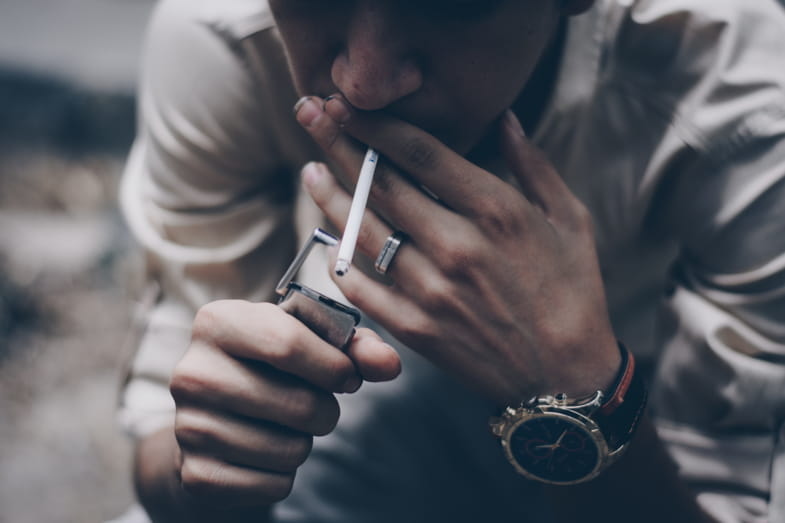 Nicotine addicted boy lighting up a cigarette